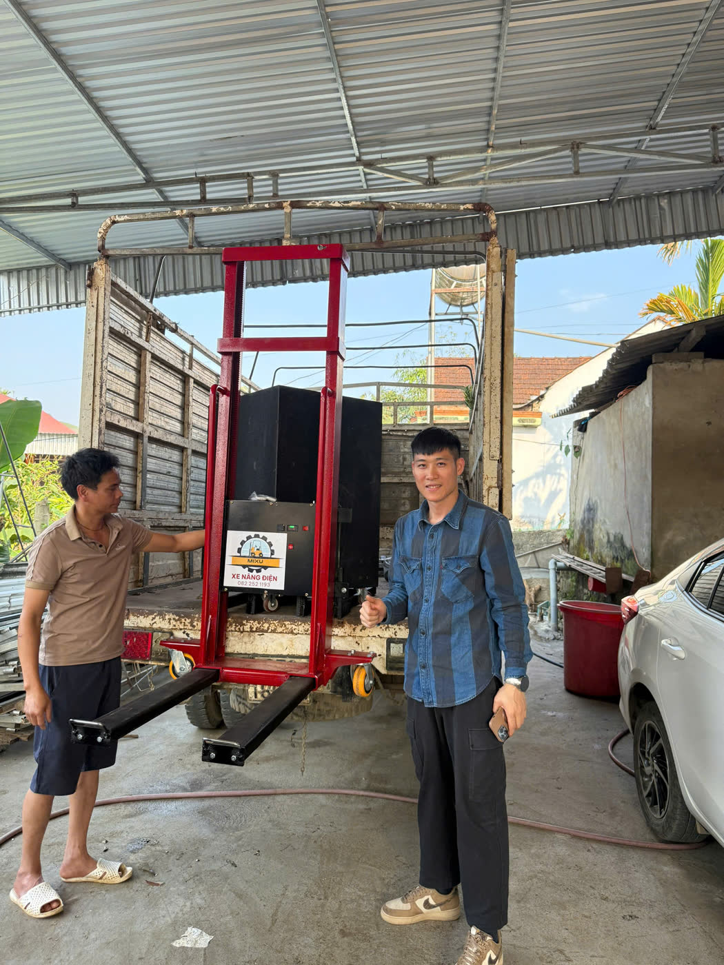 Xe nâng MIXU màu đỏ trước thùng xe tải tại Nghệ An